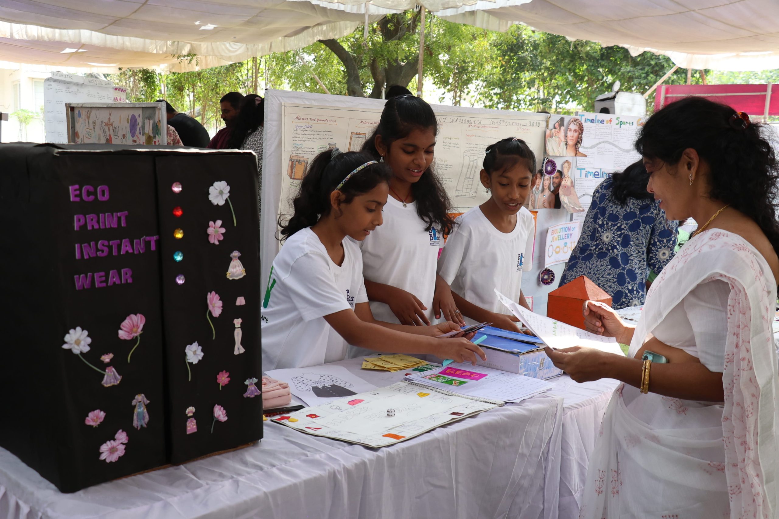 When children teach adults, an adolescent at Blue Blocks Montessori School, Hyderabad, explaining a student-designed project to a visitor at Explore Montessori 2025.